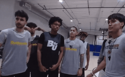 A Group Of Young Men Are Standing In A Gym With One Wearing A Shirt That Says Brother GIF