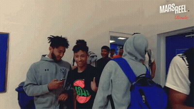 A Group Of Young Men Are Standing In A Room With A Sign That Says Mars Reel On It GIF