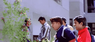 A Group Of Young Men Are Standing In Front Of A Building And Talking To Each Other . GIF
