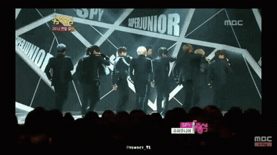 A Group Of Young Men Are Standing In Front Of A Sign That Says Superjunior GIF