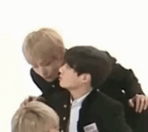 A Group Of Young Men Are Standing Next To Each Other And Kissing Each Other . GIF
