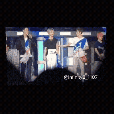 A Group Of Young Men Are Standing Next To Each Other And Looking At Each Other . GIF