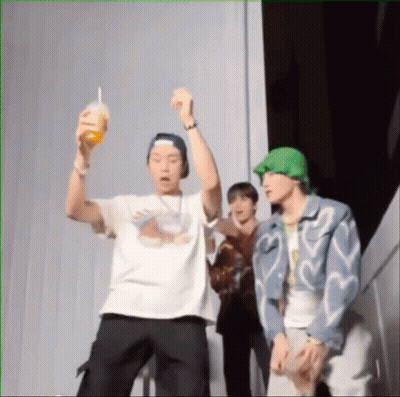 A Group Of Young Men Are Standing Next To Each Other And One Is Holding A Drink In His Hand . GIF