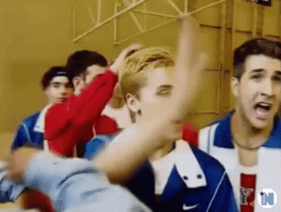 A Group Of Young Men Are Standing Next To Each Other In A Gym And One Of Them Is Yelling . GIF