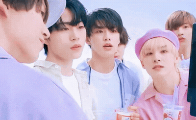 A Group Of Young Men Are Standing Next To Each Other In A Line . GIF