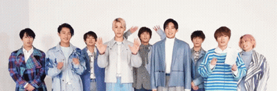 A Group Of Young Men Are Standing Next To Each Other In A Row . GIF