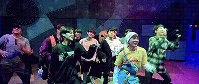 A Group Of Young Men Are Standing On A Stage Dancing . GIF