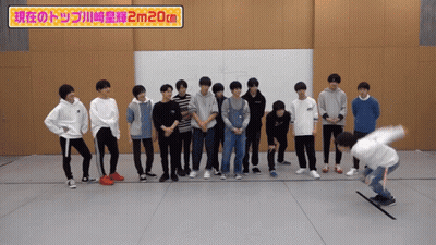 A Group Of Young Men Standing Next To Each Other With A Sign That Says 2M20cm GIF