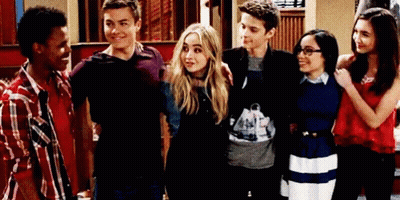 A Group Of Young People Are Posing For A Picture In A Room . GIF