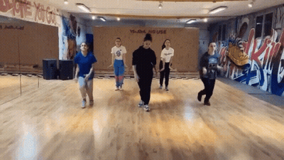 A Group Of Young Women Are Dancing In A Dance Studio With Graffiti On The Wall . GIF