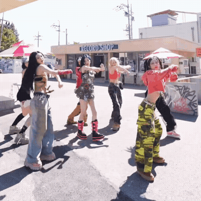 A Group Of Young Women Are Dancing In Front Of A Record Shop GIF