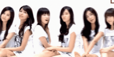 A Group Of Young Women Are Sitting In A Row With One Wearing A Shirt That Says ' A ' On It GIF
