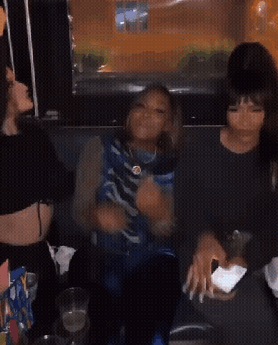 A Group Of Young Women Are Sitting Next To Each Other In A Room . GIF