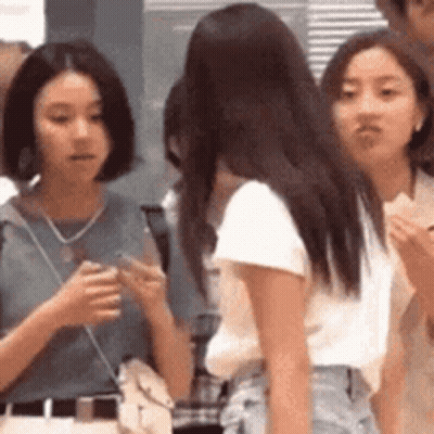 A Group Of Young Women Are Standing Next To Each Other In A Line . GIF