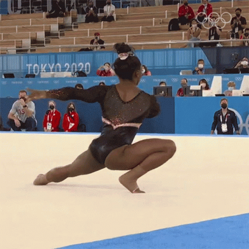 A Gymnast Performs On The Floor In Front Of A Sign That Says " Tokyo 2020 " GIF