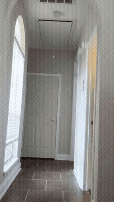 A Hallway In A House With A Ceiling Fan Above The Door GIF