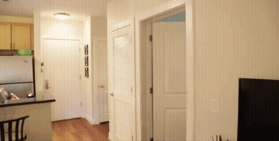 A Hallway Leading To A Kitchen And A Closet GIF