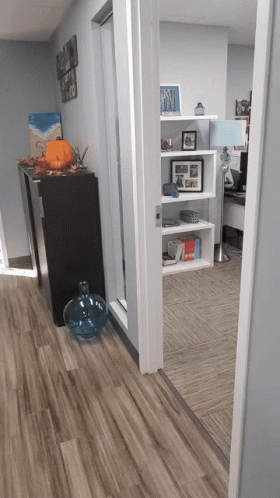 A Hallway With A Pumpkin On A Shelf And A Painting On The Wall That Says ' I Love You ' GIF