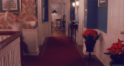 A Hallway With A Red Carpet And A Potted Plant On The Floor GIF