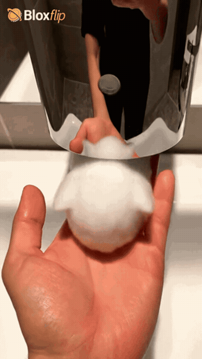A Hand Holding A Soap Dispenser In Front Of A Blox Flip Logo GIF
