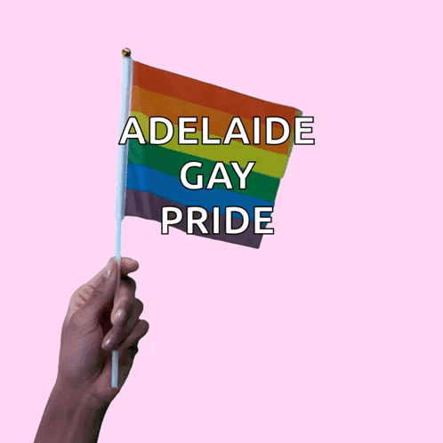 A Hand Holds A Small Rainbow Flag That Says Adelaide Gay Pride GIF