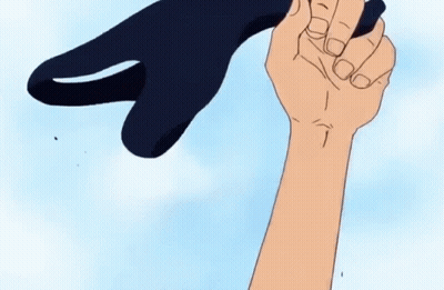 A Hand Is Holding A Black Object In The Shape Of A Shark GIF