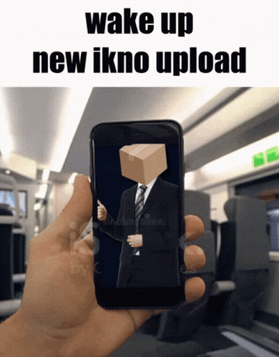 A Hand Is Holding A Cell Phone With A Man In A Suit And Tie With A Box On His Head GIF