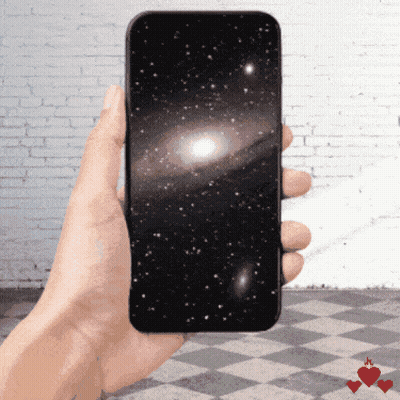 A Hand Is Holding A Cell Phone With A Picture Of The Galaxy On The Screen GIF