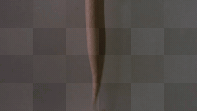 A Hand Is Holding A Cup Of Ice Cream With A Dispenser Attached To It GIF
