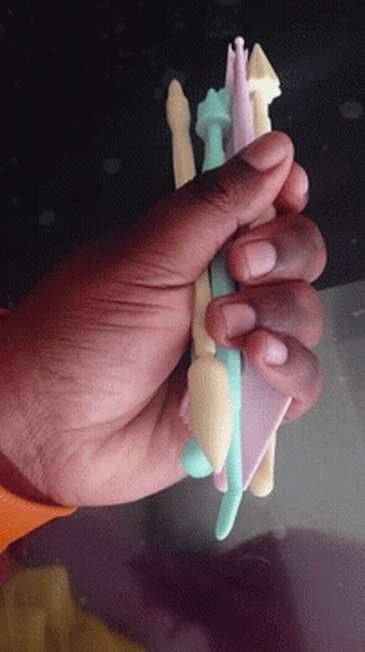 A Hand Is Holding A Stack Of Plastic Pencils GIF