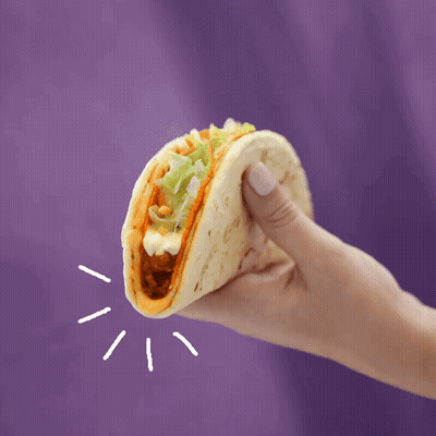 A Hand Is Holding A Taco With Lettuce And Cheese GIF
