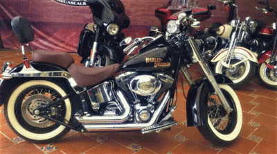 A Harley Davidson Motorcycle Is Parked In Front Of A Sign GIF