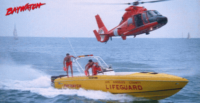 A Helicopter Is Flying Over A Yellow Lifeguard Boat GIF