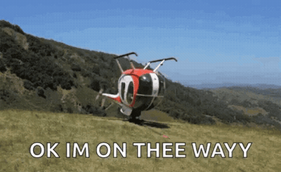 A Helicopter Is Sitting On Top Of A Grassy Hill With The Words Ok Im On Thee Wayy Written On It . GIF