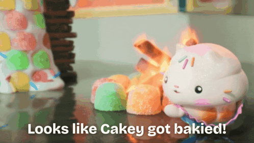 A Hello Kitty Figurine Sits On A Table Next To Candy And The Words Looks Like Cakey Got Baked On The Bottom GIF