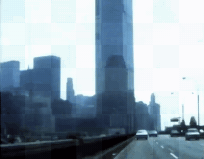 A Highway With A City Skyline In The Background GIF