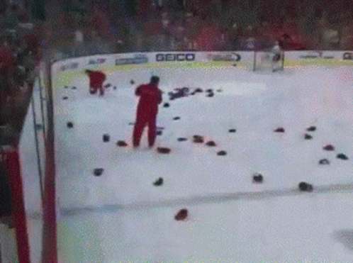 A Hockey Game Is Being Played In A Stadium With A Geico Banner On The Ice GIF
