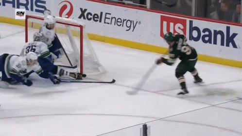 A Hockey Game Is Being Played In Front Of A Banner For Xcel Energy GIF