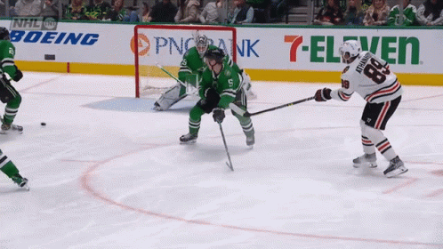 A Hockey Game Is Being Played In Front Of An Ad For 7 Eleven GIF