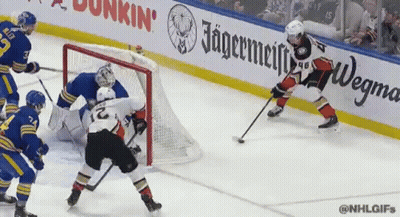 A Hockey Game Is Being Played In Front Of An Ad For Jagermeiffe GIF