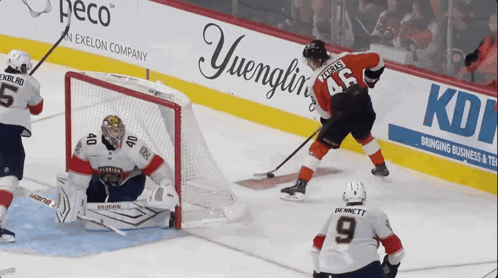 A Hockey Game Is Being Played In Front Of An Advertisement For Yuengling GIF