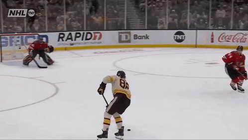 A Hockey Game Is Being Played In Front Of An Nhl Banner GIF