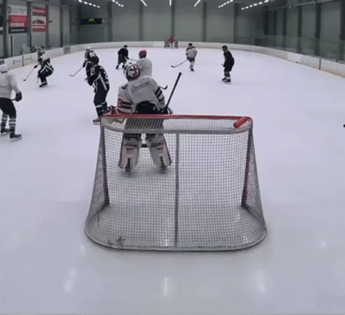 A Hockey Game Is Being Played On A Rink And The Goalie Is Wearing A Jersey That Says ' American ' On It GIF