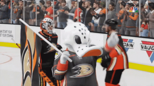 A Hockey Goalie And A Mascot On The Ice In Front Of A Sign That Says Ghn Vaughn GIF