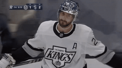 A Hockey Player For The Los Angeles Kings Is Standing On The Ice GIF