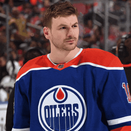 A Hockey Player For The Oilers Stands On The Ice In Front Of A Crowd GIF