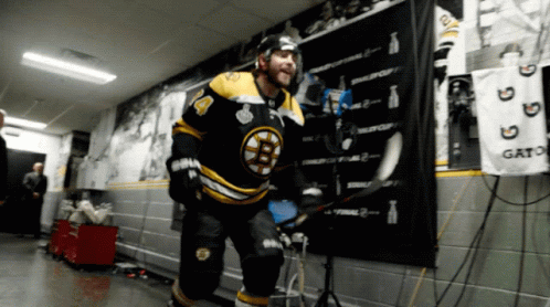 A Hockey Player In A Black And Yellow Jersey With The Number 4 On It GIF