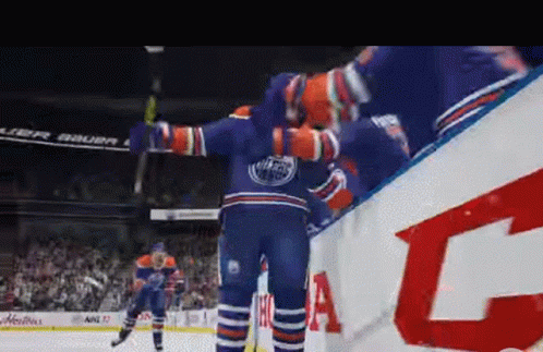 A Hockey Player In A Edmonton Oilers Jersey Is Standing On The Ice With His Arms Outstretched GIF
