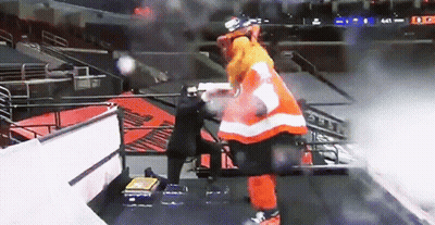 A Hockey Player In An Orange And White Uniform Stands On A Staircase GIF