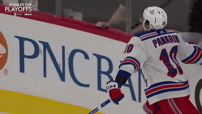 A Hockey Player In Front Of A Pncba Sign GIF